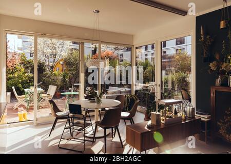 Dining room area with sun shining in from terrace in spring Stock Photo