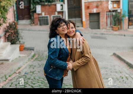 Portrait of happy mother hugging adult daughter on the street, Istanbul, Turkey Stock Photo