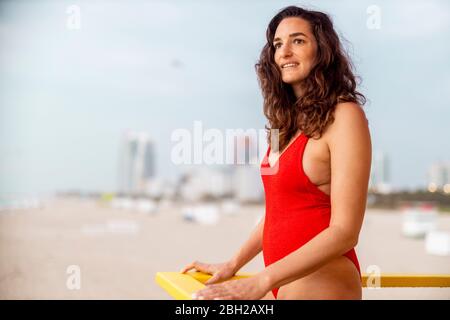 Portrait of woman in red swimsuit on lifeguard hut on Miami Beach, Miami, Florida, USA Stock Photo