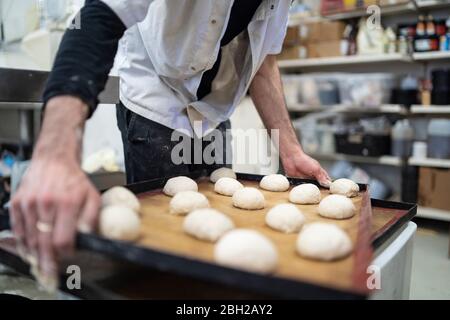 Close-up of baker holding tray with bread rolls in bakery Stock Photo
