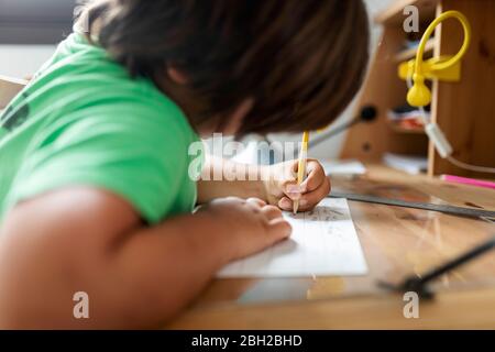 Boy doing his homework, sitting at desk Stock Photo