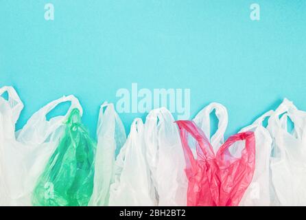 Plastic disposable shopping bags on blue background. Ecology environment concept Stock Photo