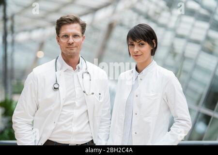 Two confident doctors standing in atrium Stock Photo