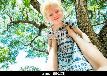 Father's arms lifting up happy  little daughter Stock Photo