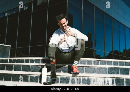 Disabled athlete with leg prosthesis having a break from exercising in the city Stock Photo