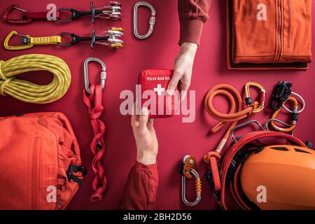 Overhead view of woman handing over first aid kit to man with climbing equipment in background Stock Photo