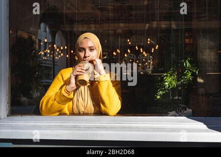Portrait of young woman drinking smoothie in a cafe Stock Photo