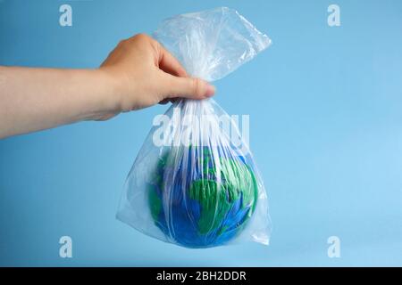 World globe in plastic bag. Environment pollution. Garbage recycling. Pollution problem concept. Stock Photo