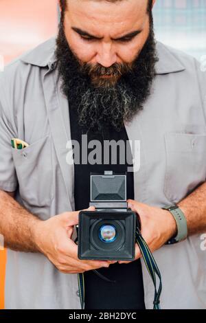 Bearded man taking photo with camera Stock Photo