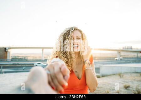 Portrait of happy young woman holding hands at evening twilight Stock Photo