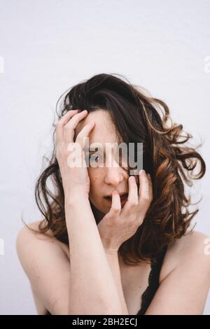 Portrait of young woman with hands on her face Stock Photo