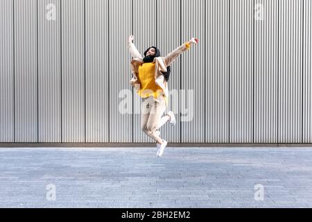 Portrait of happy young woman jumping in the air Stock Photo