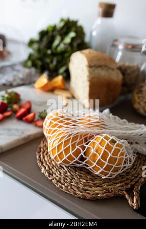 Oranges in net on kitchen counter Stock Photo