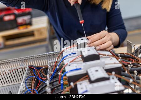 Close-up of electrician working on circuitry in workshop Stock Photo