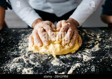 Close-up of hands preparing dough in kitchen at home Stock Photo