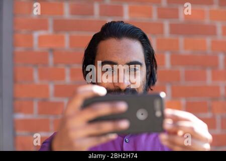 Young man taking a selfie with his smartphone Stock Photo