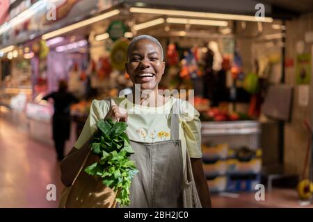 Portrait of happy woman buying groceries in a market hall Stock Photo