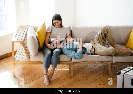Affectionate young couple in love relaxing on couch at home Stock Photo