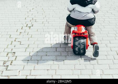 Back view of little boy on bogie wheel, partial view Stock Photo