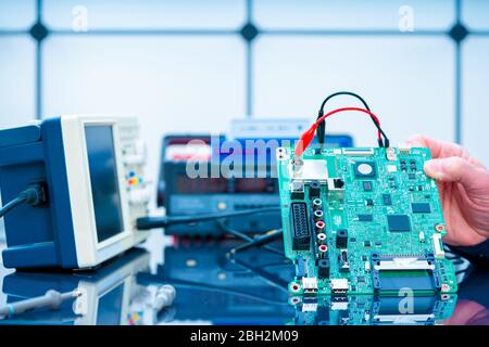 Debugging electronics device. PCB witch microcontroller in electronics laboratory Stock Photo