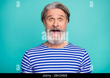 Close-up portrait of his he nice attractive cheerful cheery crazy grey-haired man wearing striped jumper opened mouth isolated over bright vivid shine Stock Photo