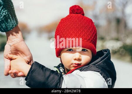 Portrait of little boy wearing red bobble hat