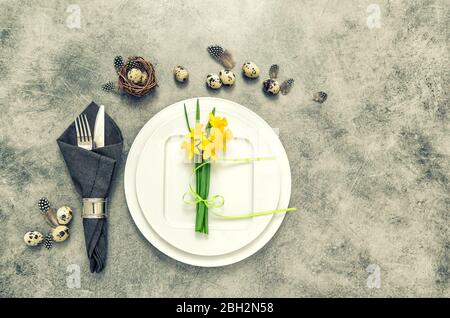 Easter table place setting decoration with eggs and flowers. Vintage style toned picture Stock Photo