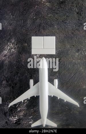 Airplane with wooden cubes on which you can enter your date stands on a dark background. Top views Stock Photo