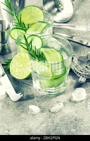 Cold drink with cucumber, lime, ice and rosemary. Fresh summer lemonade Stock Photo