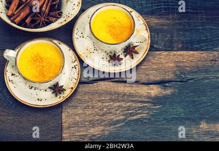 Hot curcuma turmeric milk drink with spices. Vintage style toned picture Stock Photo