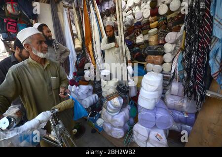 Peshawar, Pakistan. 23rd Apr, 2020. A man arranges traditional caps at a shop ahead of the holy month of Ramadan in northwest Pakistan's Peshawar. Muslims throughout the world will mark the month of Ramadan in the Islamic calendar, with dawn to dusk fasting. It is customary to break the fast with dates. (Photo by Hussain Ali/Pacific Press) Credit: Pacific Press Agency/Alamy Live News Stock Photo