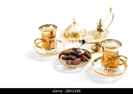 Tea glasses with dates on white background. Oriental hospitality Stock Photo