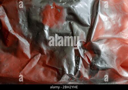 Silver paint on an orange surface. Plastic film painted with silver paint. Abstract multitask background. Selective focus. Stock Photo