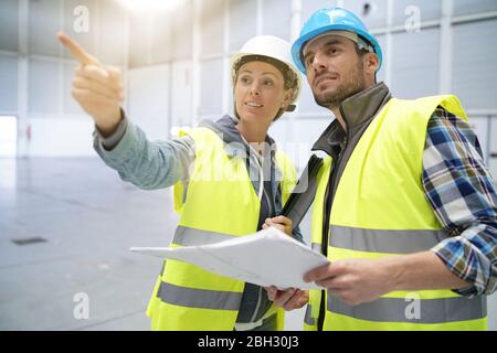 Male and female concstruction coworkers in warehouse Stock Photo