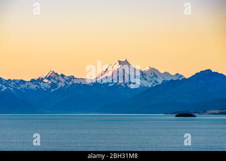 Beautiful landscape of Mount Cook peak covered in snow at dusk after sunset seen across Lake Pukaki. Aoraki / Mount Cook National Park, New Zealand. Stock Photo