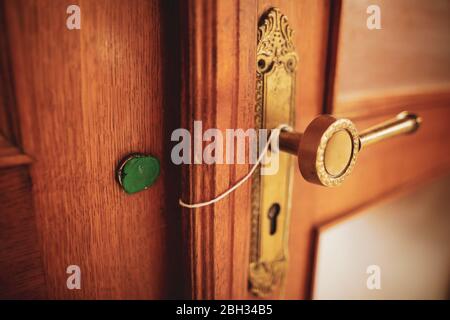 Shallow depth of field (selective focus) details with a broken wax seal on an old massive wooden door. Stock Photo