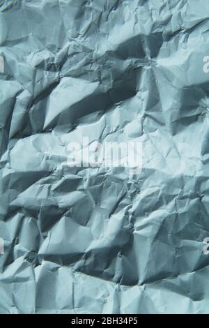 A crumpled paper background. White and grey color. Vertical. Stock Photo