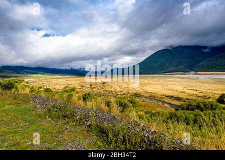 Mountain, hills, plains, meadows, prairie, fields and river flowing. Waimakariri river valley, near Arthur's Pass and Lake Pearson, New Zealand. Stock Photo