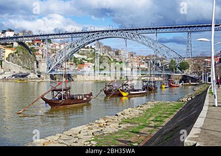 The historic double deck metal arch Ponte Luis I spanning the granite valley of the river Douro in Porto, Portugal, with historic cargo boats Stock Photo