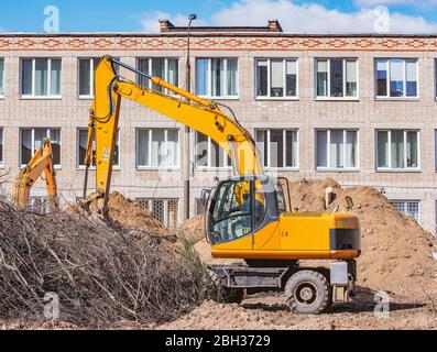 Excavator digs a hole on the construction site. Stock Photo