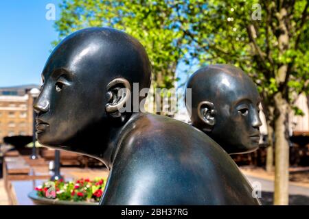 'Two Men on a Bench' (1995) sculpture by Giles Penny, Canary Wharf, London, UK Stock Photo