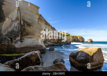 Sculpted cliffs, eroded rock formations and rough sea waves at Tunnel Beach, Otago region, South Island, New Zealand Stock Photo