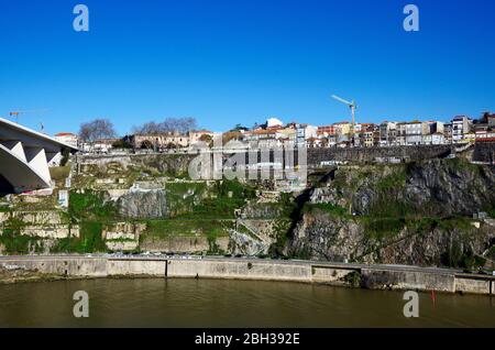 Steep north bank of the River Douro upstream from the Ponte do Infante, roads and a railway cut into it,otherwise mostly living rock, Porto Portugal. Stock Photo
