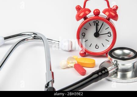 A picture of stethoscope, medicines and clock. It is for medical reminder. Stock Photo