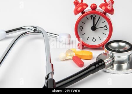 A picture of stethoscope, medicines and clock. It is for medical reminder. Stock Photo