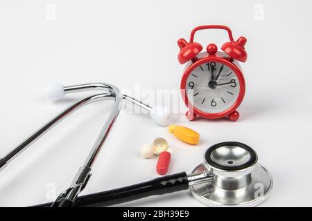 A picture of stethoscope, medicines and clock. It is for medical reminder. Stock Photo
