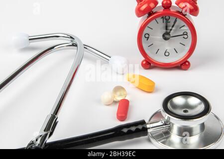 A picture of stethoscope, medicines and clock. It is for medical reminder. Stock Photo