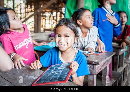 Cambodian school children smile for the camera in a school in the Kampong Phluk (floating) village, Siem Reap Province, Cambodia. Stock Photo