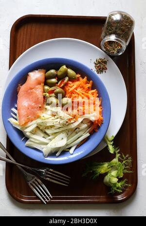 Smoked salmon with fennel, carrots, olive and herbs on blue plate. Wooden background. Top view. Food concept. Stock Photo