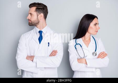 We don't talk anymore. Photo of handsome doc guy professional lady patient consultation virology clinic arms crossed look side ignorance concept wear Stock Photo